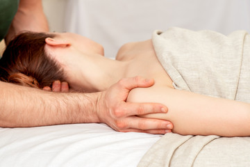 Young woman receiving shoulder massage, close up.