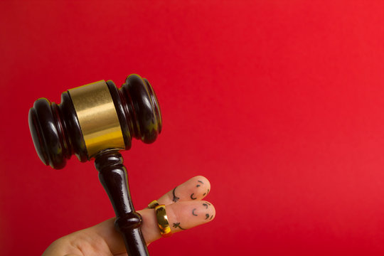 Purposal devorce creative concept. Painted happy fingers smiley in love against red background with court libra