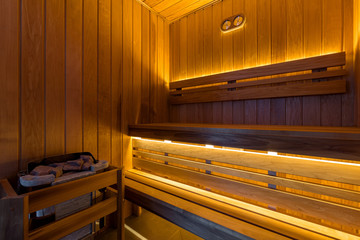 Sauna, made of natural wood with an oven. Lighting the sauna.