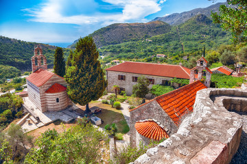 Stone church with bell tower at Gradiste monastery near Buljarica, Montenegro. - obrazy, fototapety, plakaty