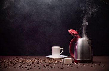 Electric kettle and coffee beans on dark background