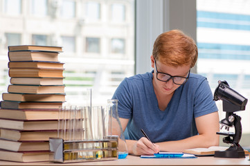 Young student tired and exhausted preparing for chemistry exam