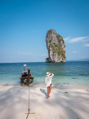 Koh Poda Krab Thailand, woman with hat on the beach of Koh Poda Island on a bright day with blue sky © Fokke Baarssen