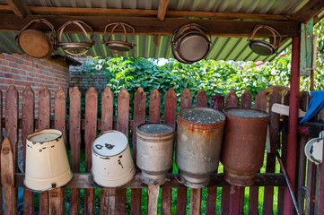 Fototapeta premium Vintage milk buckets drying on the fence