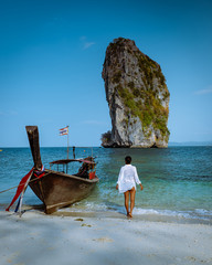Koh Poda Krab Thailand, woman with hat on the beach of Koh Poda Island on a bright day with blue sky © Fokke Baarssen
