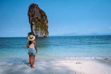 Koh Poda Krab Thailand, woman with hat on the beach of Koh Poda Island on a bright day with blue sky © Fokke Baarssen