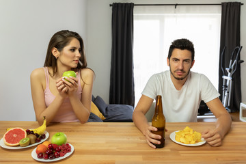 A man leads a wrong lifestyle, he eats chips and beer.