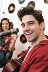 Image of young happy caucasian people performing at radio program