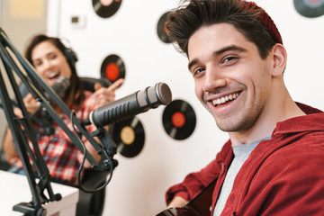 Image of young happy caucasian people performing at radio program