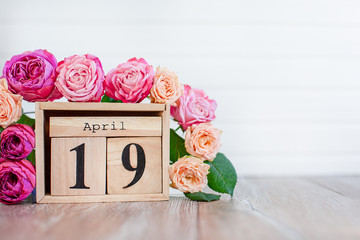 Greeting card Happy Valentine's Day wooden calendar and pink roses wooden background. Copy space.