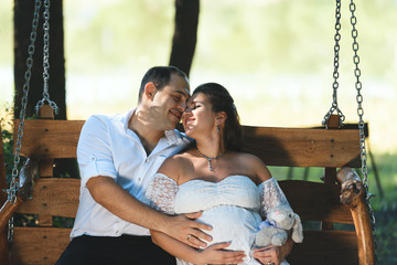 smiling couple on wooden swing