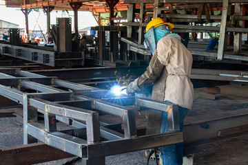 The welder is welding a steel structure work with process Flux Cored Arc Welding(FCAW) and dressed...