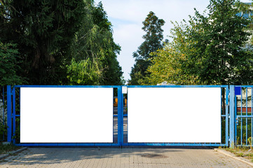 Blank white advertising banner mounted on the fence of industrial building