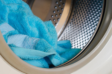Bath towel inside the washing machine. Laundry in a home washing machine. Eye level shooting....