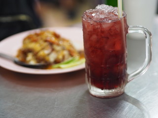 Black iced tea Drink in Crystal clear water and roasted red pork food