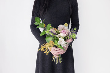 black dress woman florist holding colorful flower bouquet