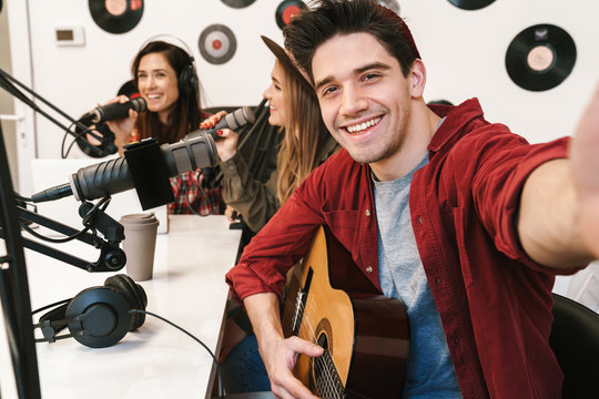 Image of young happy caucasian people performing at radio program
