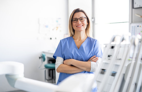 A portrait of dental assistant in modern dental surgery, looking at camera.