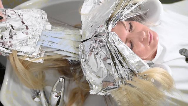 Removing aluminum foil over sink. Concept of coloring hair, modern look, hair care