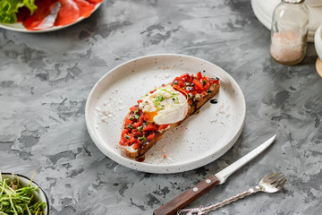 Sandwich with red fish, poached egg, balsamic vinegar and micro-greens