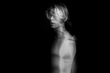 Artistic Beautiful fuzzy mystical mysterious ambiguous original conceptual profile side portrait of young blonde naked man on a black background. Black and white photo. long exposure. Emotional creepy