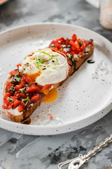 Sandwich with red fish, poached egg, balsamic vinegar and micro-greens
