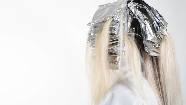 Presentation of the method of dyeing the hair with the help of aluminum foil on a white background. Copy space