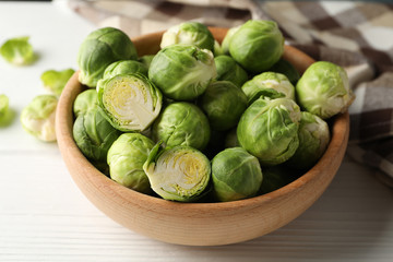 Bowl with brussels sprout on wooden background, close up