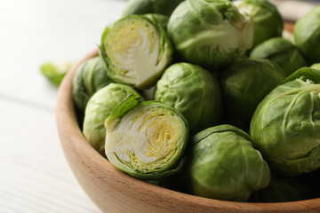 Bowl with brussels sprout on wooden background, close up