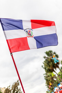The flag of the Dominican republic wit a cloudy sky in the background 