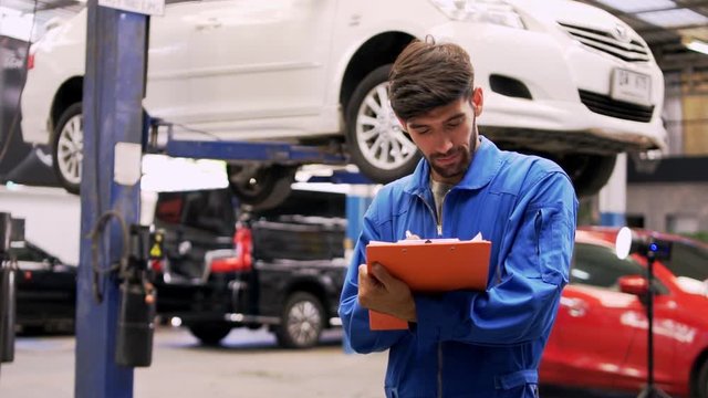 Man specialist an auto mechanic in a car service checks the machine diagnostics. with his team . 