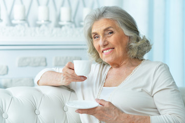 Portrait of beautiful smiling senior woman drinking tea