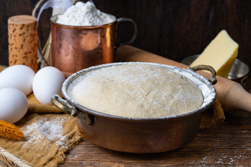 Dough and ingredients for homemade bread, khachapuri or pizza. Dark food background. Copy space for text. Horizontal