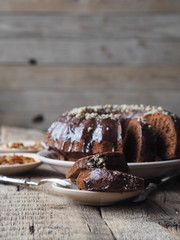Festive homemade cakes. Round chocolate muffin, large muffin or cake with chocolate icing on a dark wooden background, place for text.