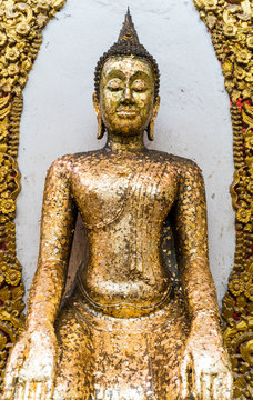 Closeup buddha statue  covering with gold leaf in Thai temple