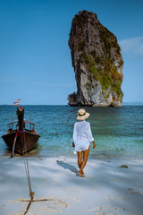 Koh Poda Krab Thailand, woman with hat on the beach of Koh Poda Island on a bright day with blue sky © Fokke Baarssen