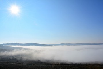 Fototapeta premium fog between hills in a rural area