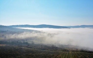 Fototapeta premium fog between hills in a rural area
