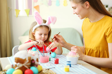 Mom and daughter paint Easter eggs for the holiday. Easter traditions.