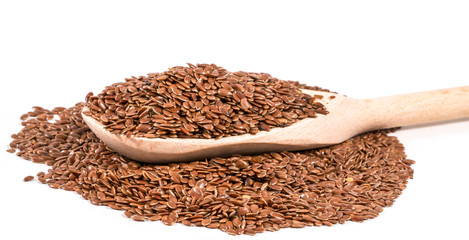 spoon with seeds of lien on white background