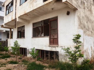 Fototapeta na wymiar Exterior of abandoned residential building with broken window glass