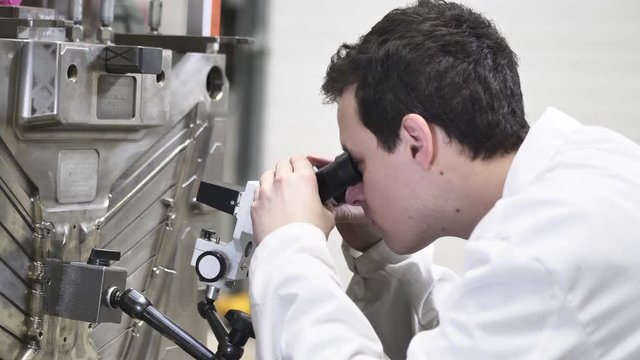 Quality Engineer Checks Deficiencies on the Injection Mold by a Microscope, Checking the Technical Condition of the Injection Mold in Automotive Factory, Industrial Concept