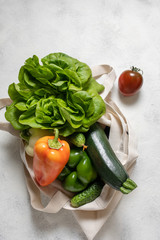 Paper and cotton bag of healthy vegetables, flat lay food on the table. Top view, copy space.