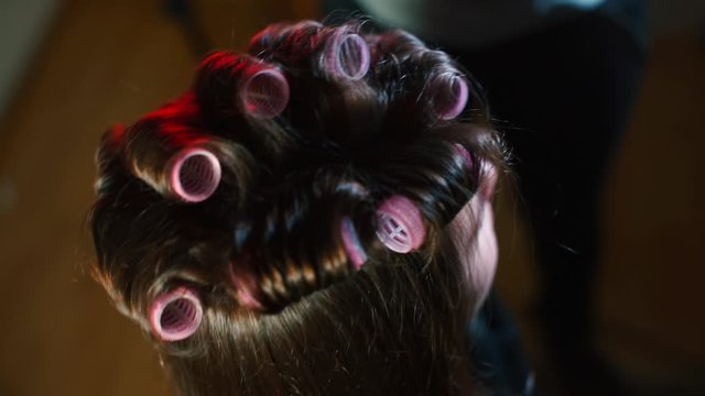 Close-up of hair with curlers of a girl at the hairdresser.