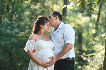 man kissing pregnant woman in forehead