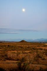 South Africa, A full moon hovers early in the morning over the Klein Karoo countryside in South Africa