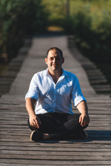 smiling meditating man on bridge