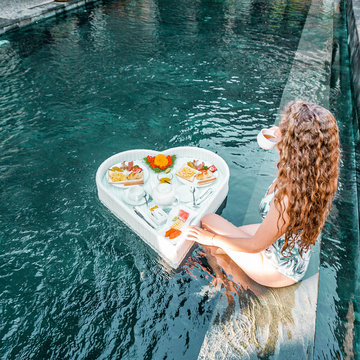 Chica desayunando en piscina