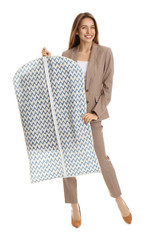 Young woman holding garment cover with clothes on white background. Dry-cleaning service