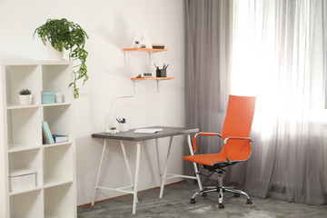 Stylish room interior with comfortable workplace near window